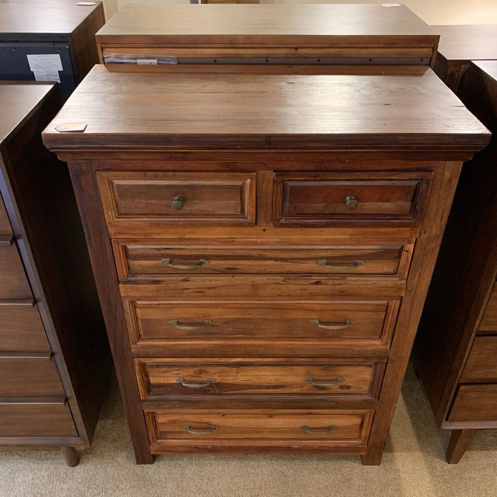Wooden dresser with multiple drawers in a store setting