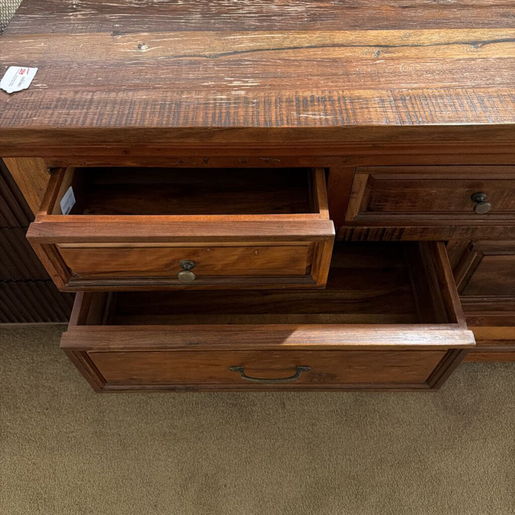 Wooden dresser with open drawer on a carpeted floor
