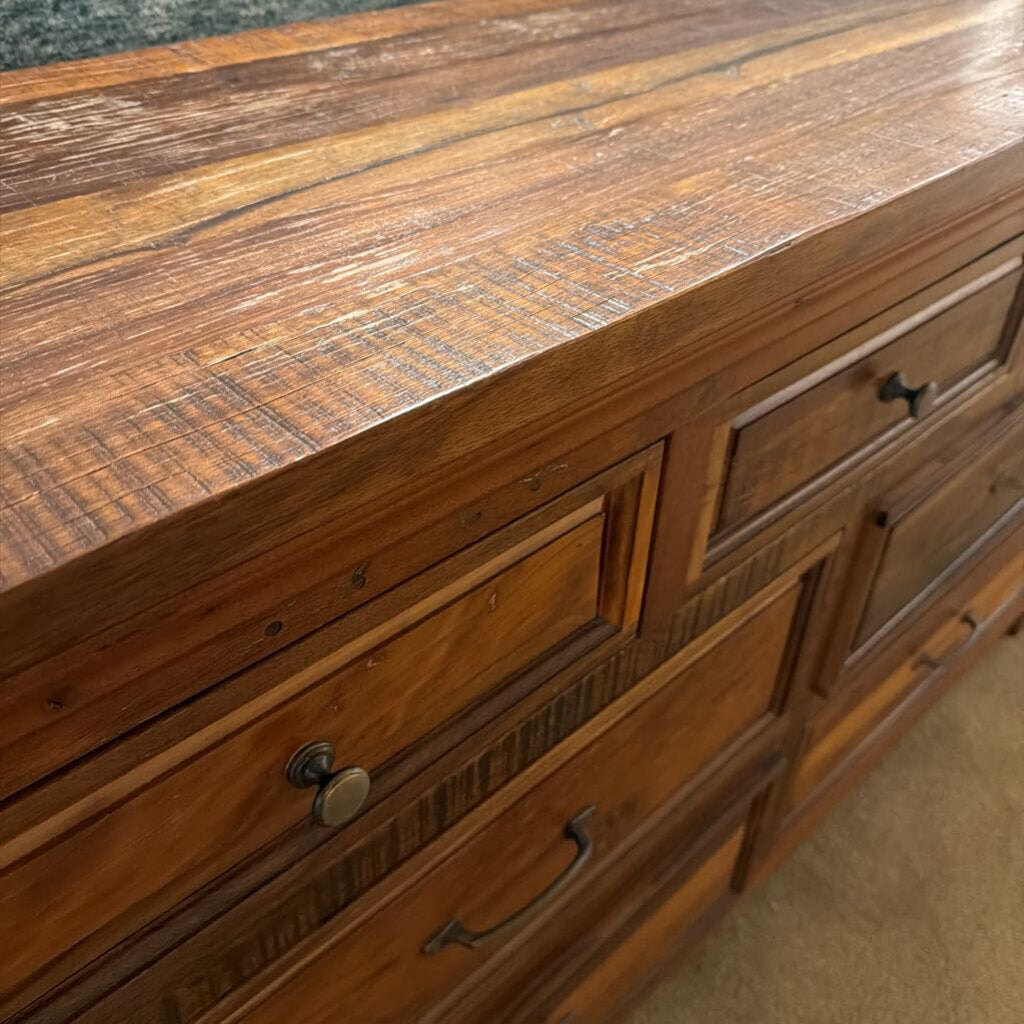 Wooden dresser with a focus on the top surface and drawers.