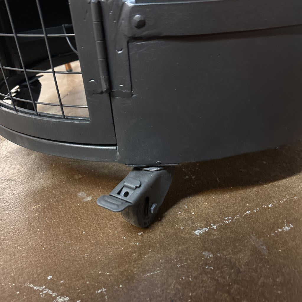 Black pet crate with a paw print on a brown floor