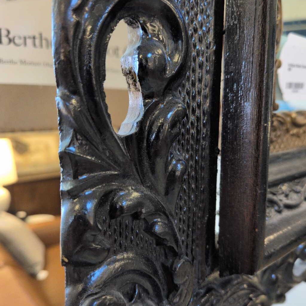 Decorative metal frame with intricate designs, blurred background