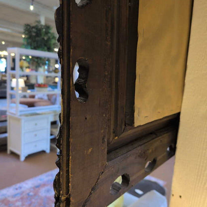 Close-up of an old wooden frame with a blurred indoor setting in the background