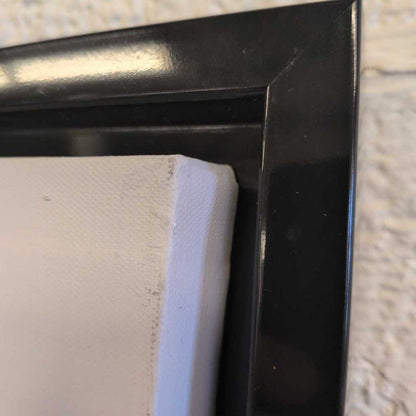 Close-up of a black frame corner with a white mat.