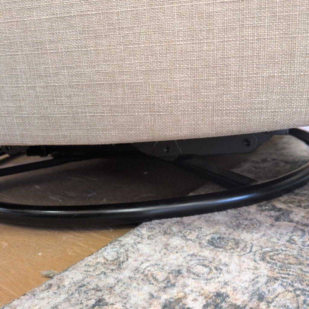 Close-up of a textured surface with a chair leg and black metal base.