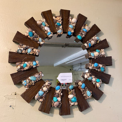 Decorative wreath with seashells and wooden elements on a plain background