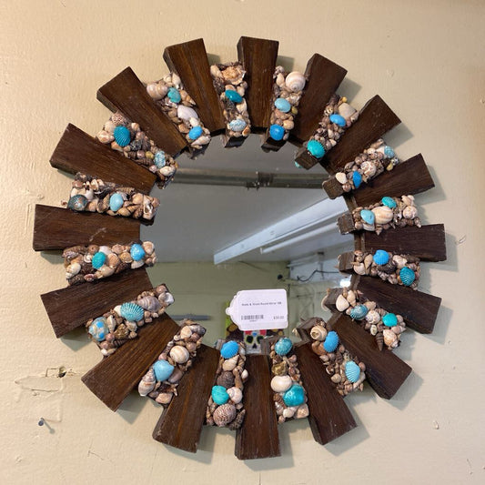 Decorative wreath with seashells and wooden elements on a plain background
