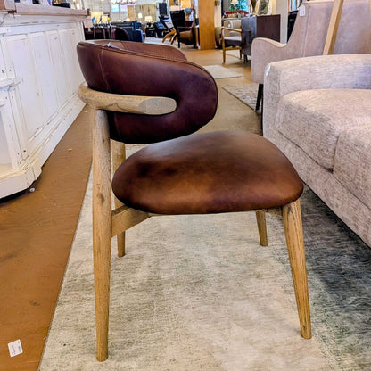 Brown leather chair with wooden frame in a furniture store setting