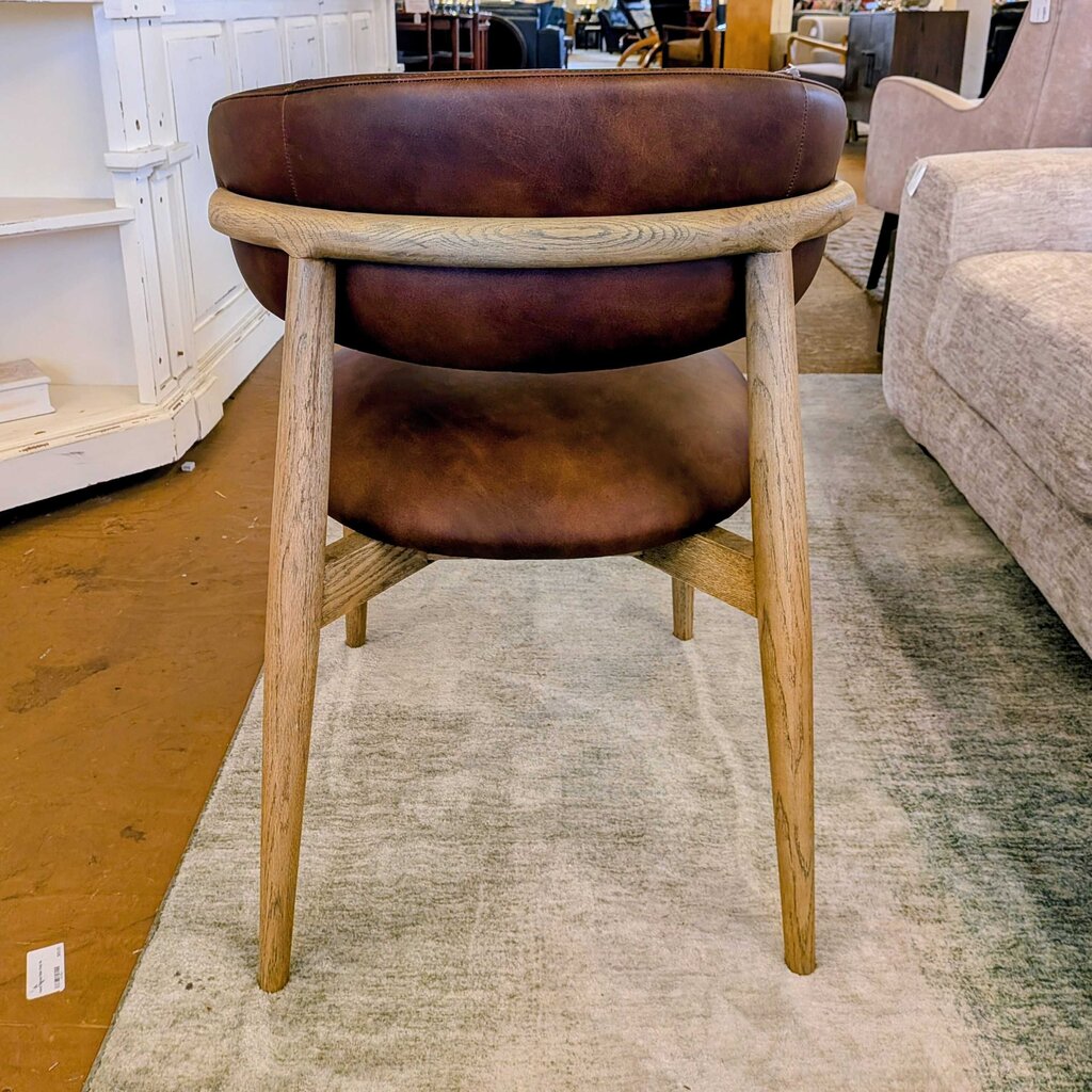 Round wooden table with brown leather seats in a store setting