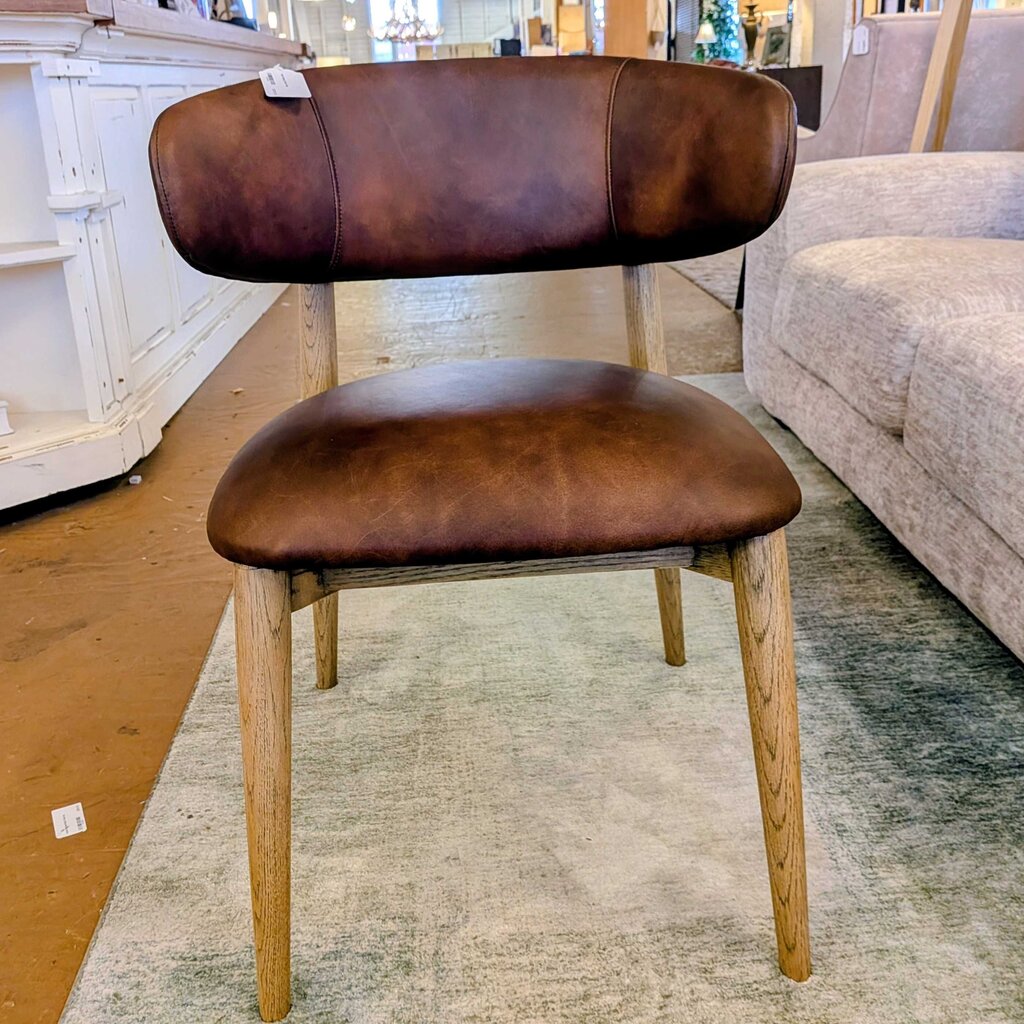 Brown leather chair with wooden legs in a room setting