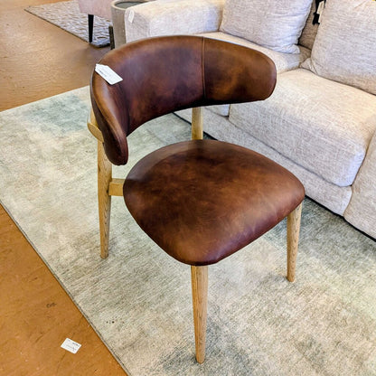 Brown leather chair with wooden legs in a room setting