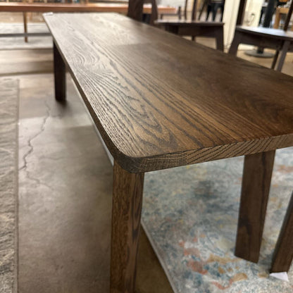 Wooden table in a room with a patterned rug and blurred background