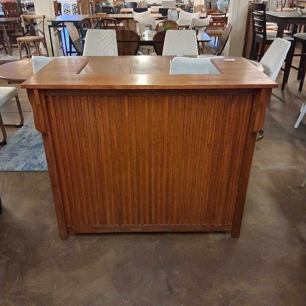 Wooden reception desk in a room with chairs and tables