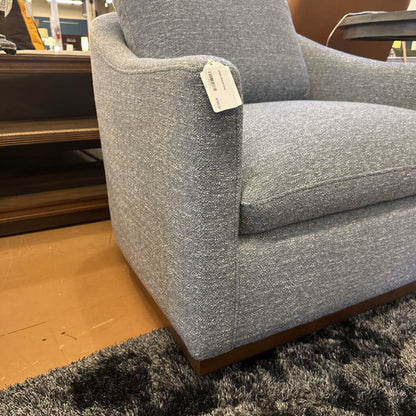 Gray upholstered chair with a price tag in a store setting