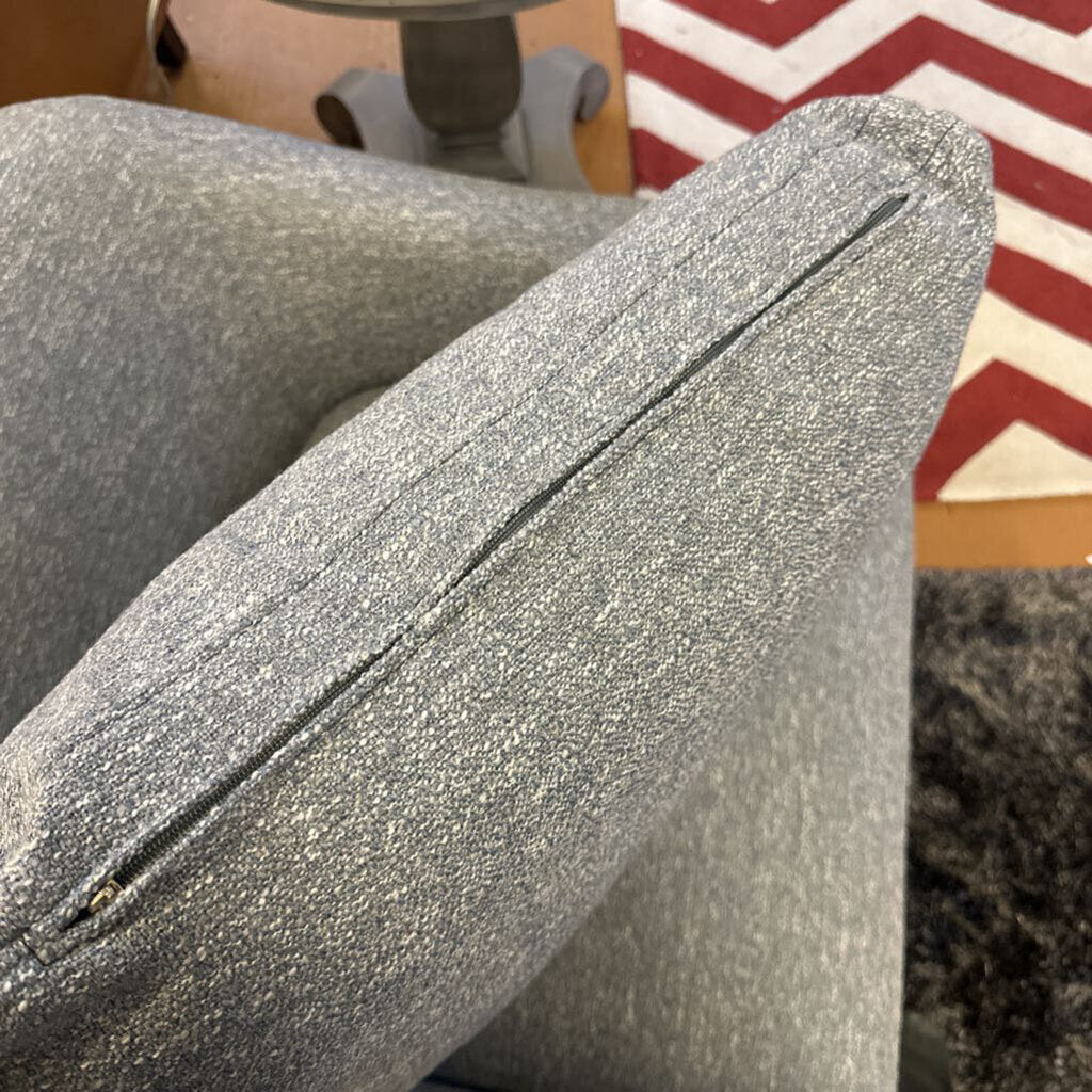 Close-up of a textured gray cushion on a chair with a blurred background