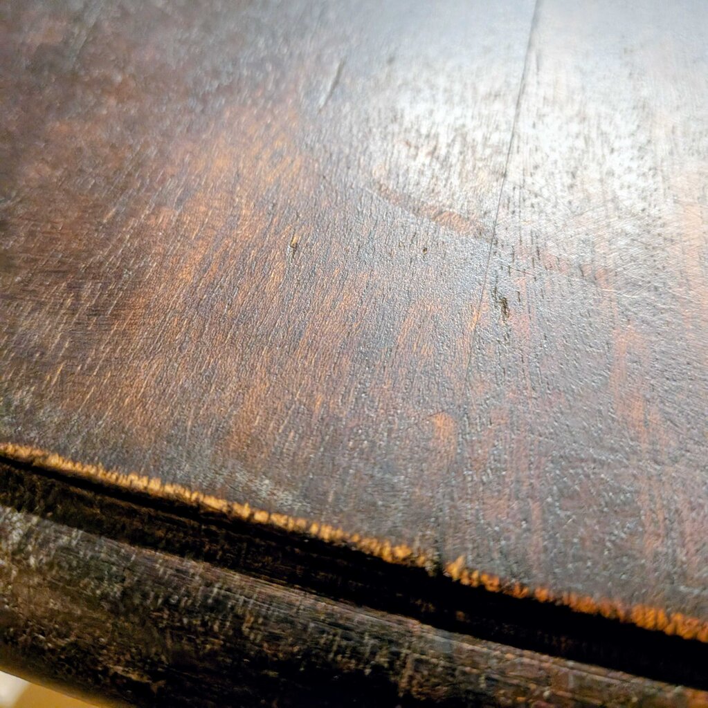Close-up of a wooden surface with visible grain and wear.