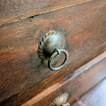 Close-up of a wooden surface with a metal handle and worn area.