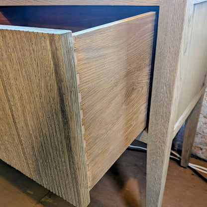 Close-up of a wooden drawer with a visible grain pattern.