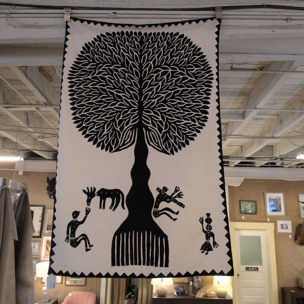 Decorative wall hanging with a black tree design and figures in a store setting