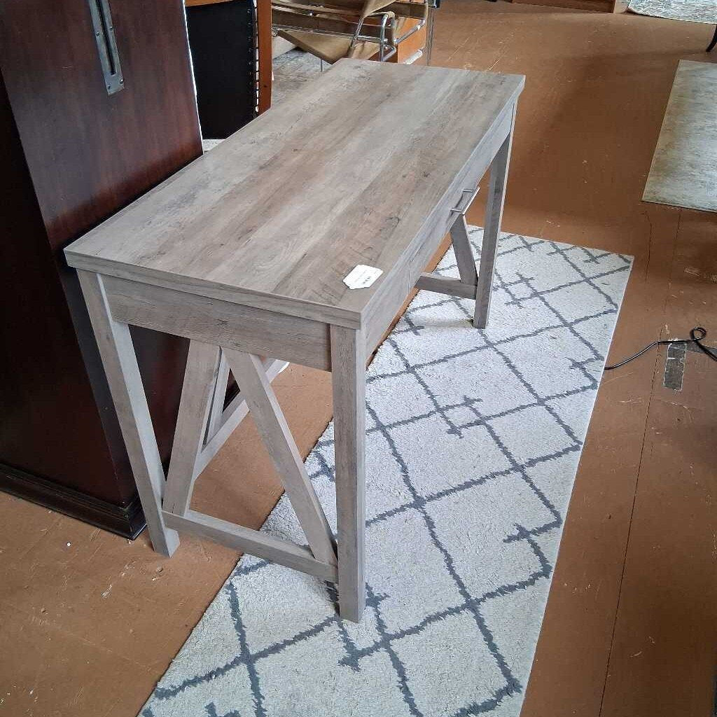 Wooden table with a grayish finish on a patterned rug