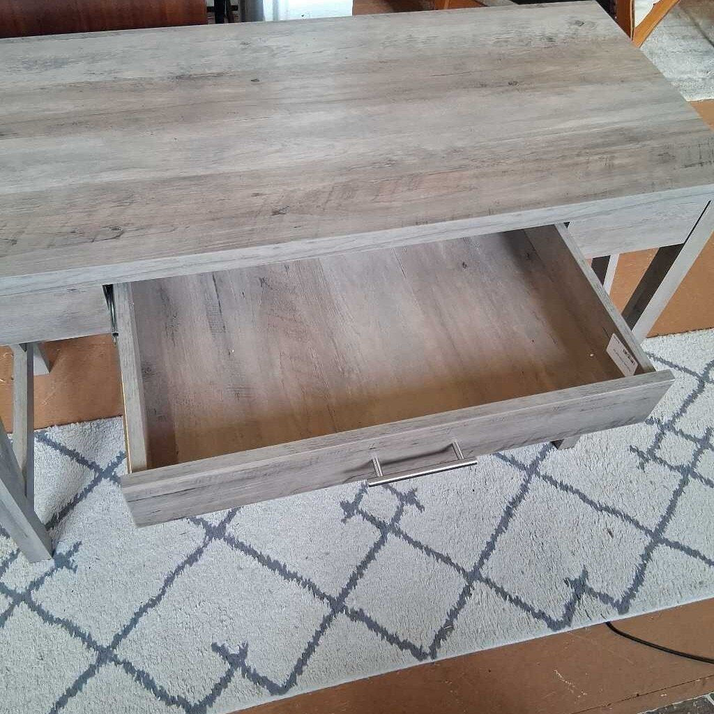 Wooden desk with an open drawer on a patterned rug