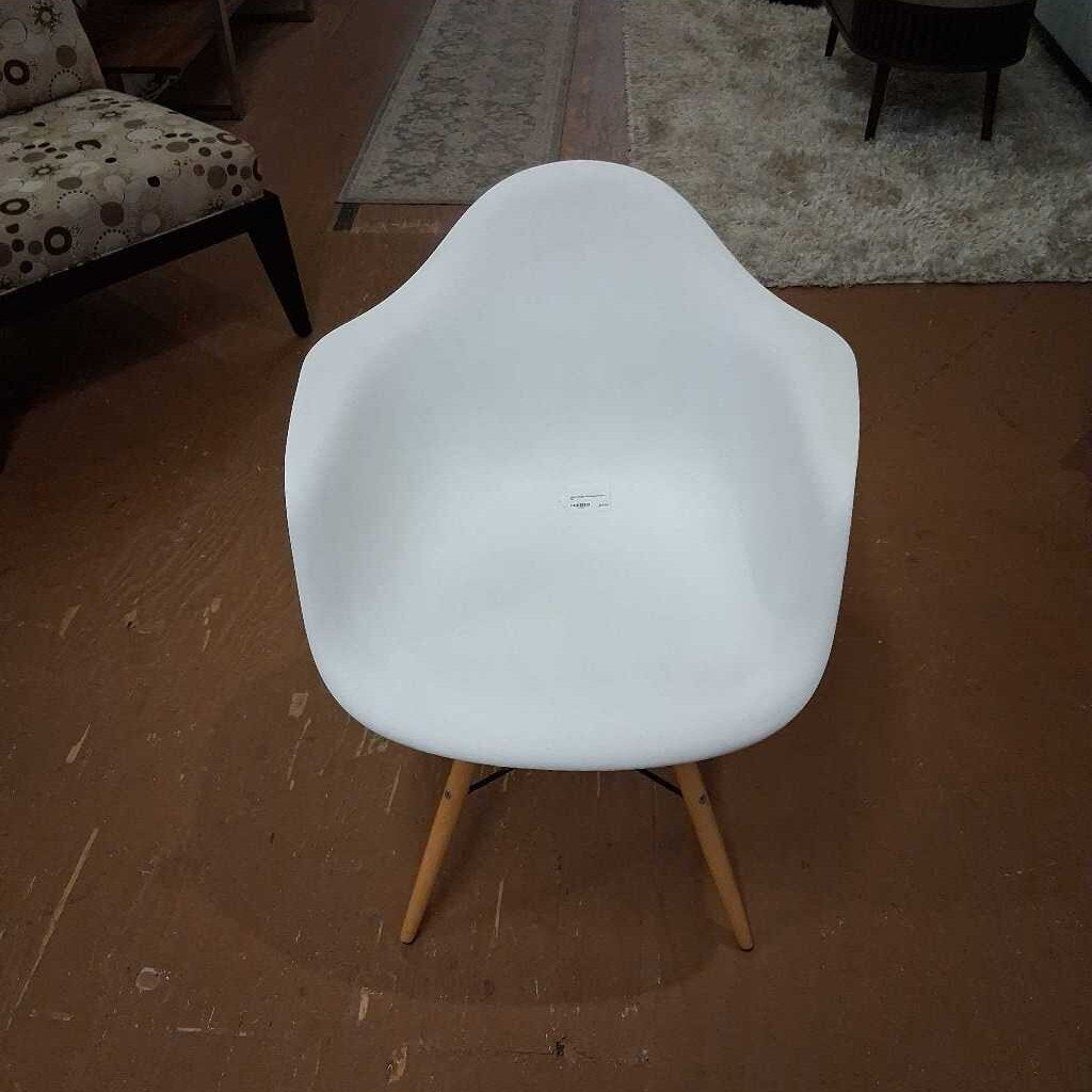 White chair with wooden legs on a brown floor