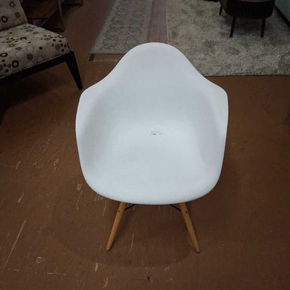 White chair with wooden legs on a brown floor