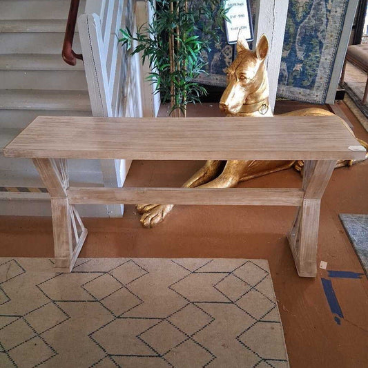 Wooden bench in a room with a gold statue and decorative rug
