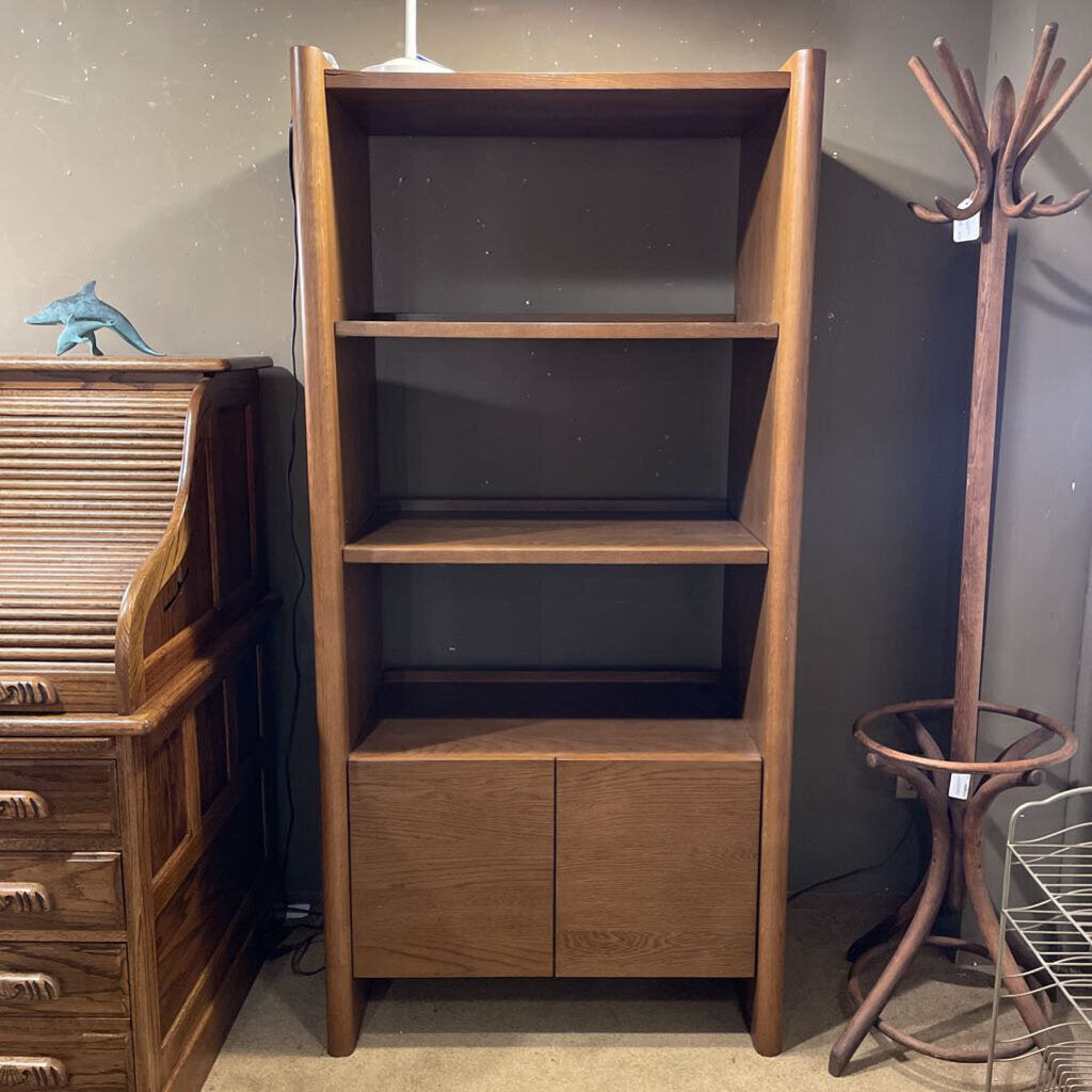 Wooden bookshelf with a coat rack and other furniture items in a room.