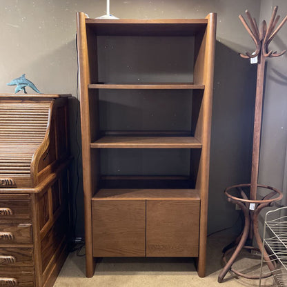 Wooden bookshelf with a coat rack and other furniture items in a room.