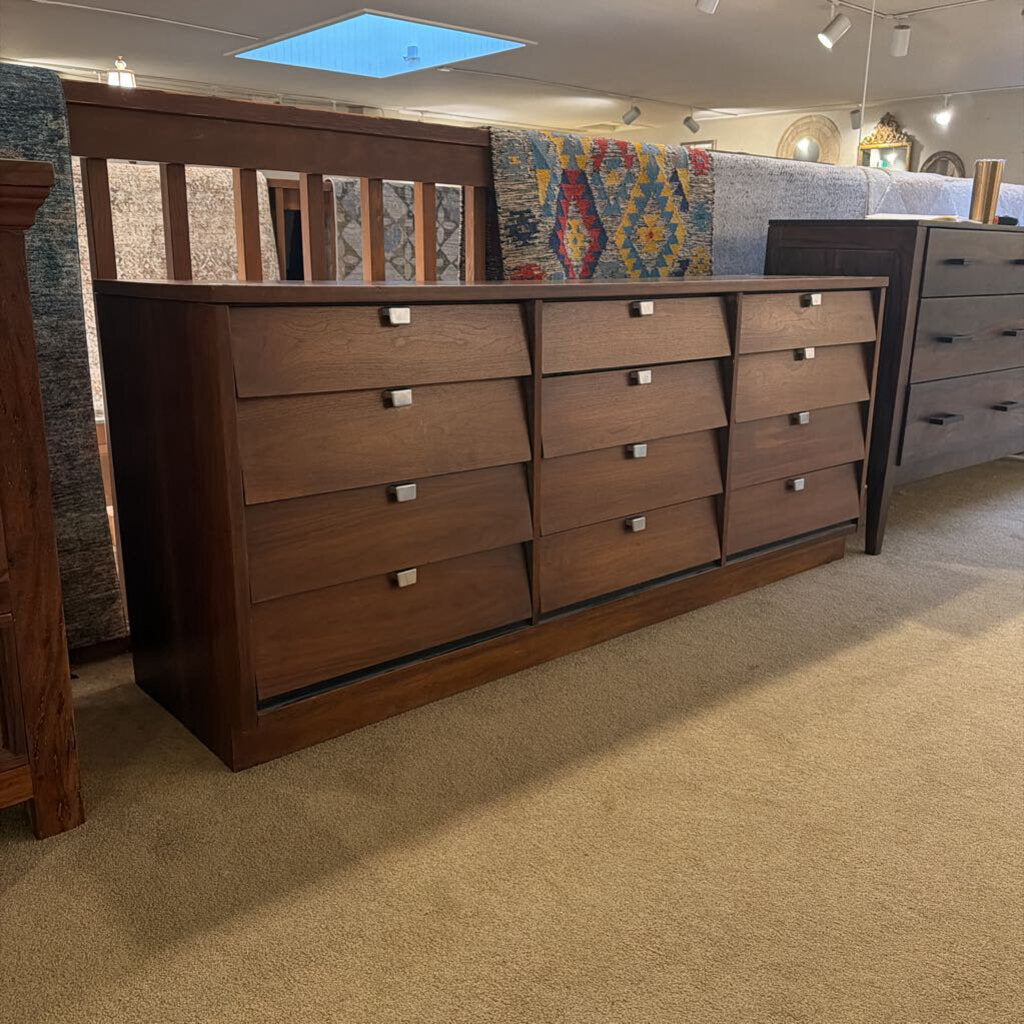Wooden dresser with multiple drawers in a showroom setting