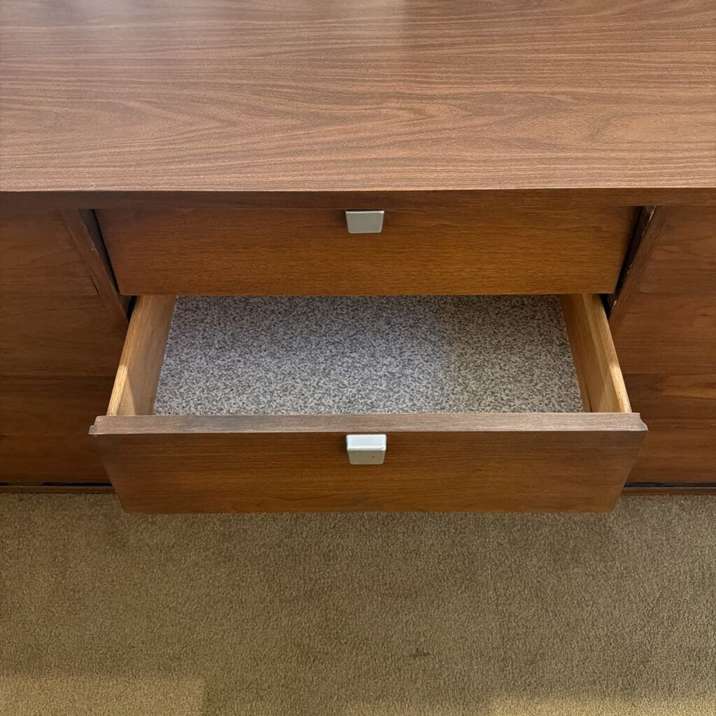 Wooden drawer with a gray interior on a wooden surface.