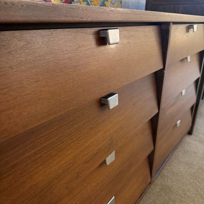 Wooden dresser with metal handles in a room setting