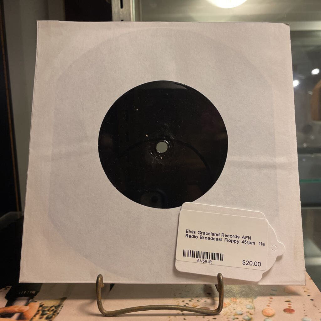 Record in a white sleeve with a price tag on a stand