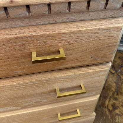 Wooden dresser with gold handles on a blurred background