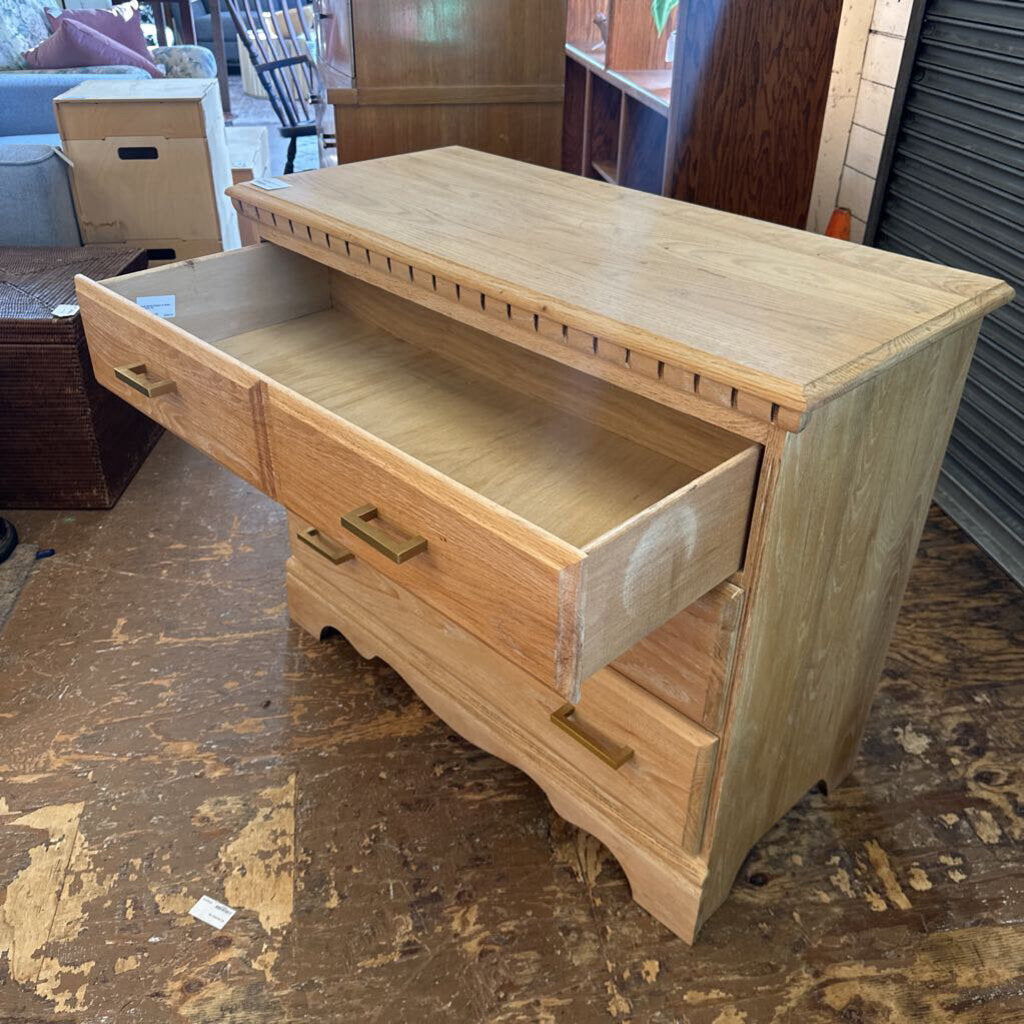 Wooden dresser with open drawer on a wooden floor