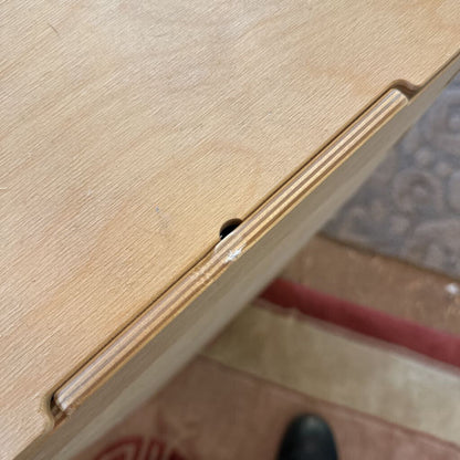 Close-up of a wooden surface with a small black object on it.