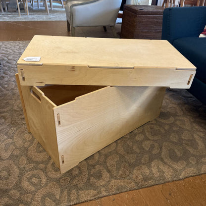 Wooden storage bench with a lift-top design on a patterned carpet.
