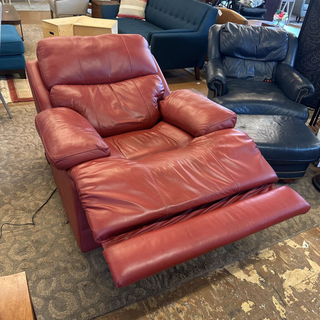 Red leather recliner sofa in a room with other furniture.