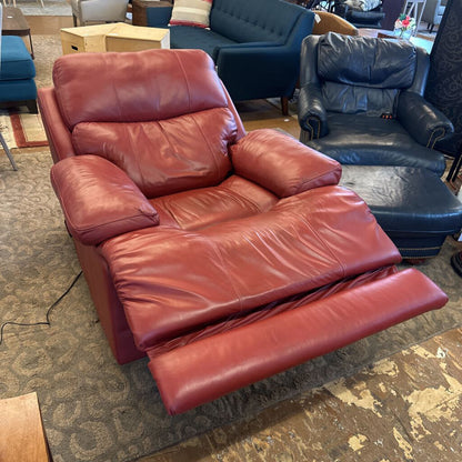 Red leather recliner sofa in a room with other furniture.