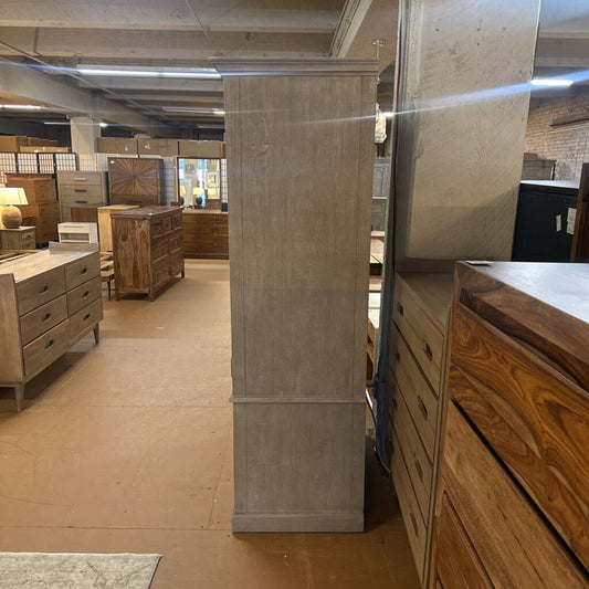 Furniture store with wooden dressers and a large mirror on the wall.