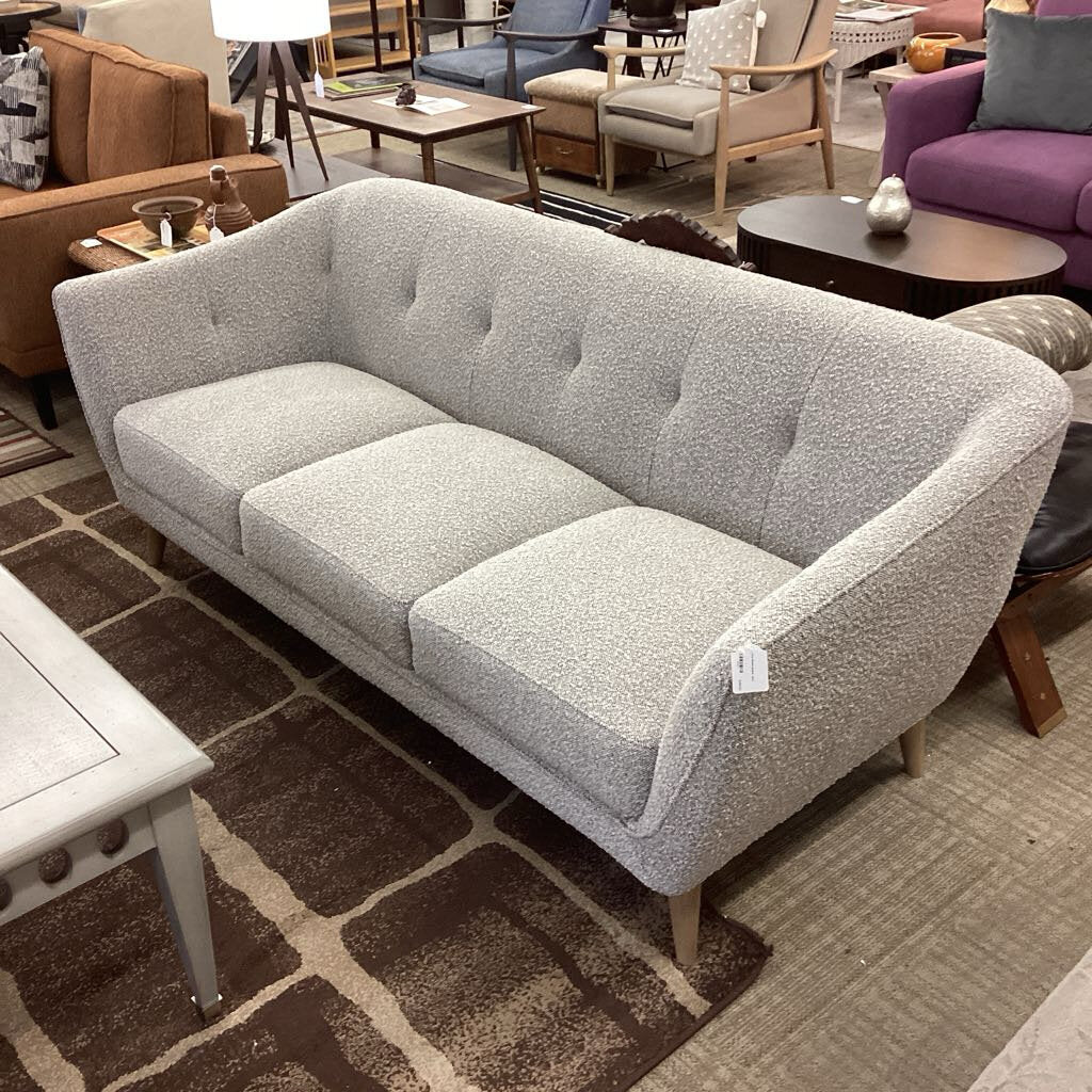 Gray sofa in a showroom with other furniture in the background