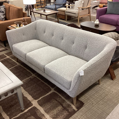 Gray sofa in a showroom with other furniture in the background