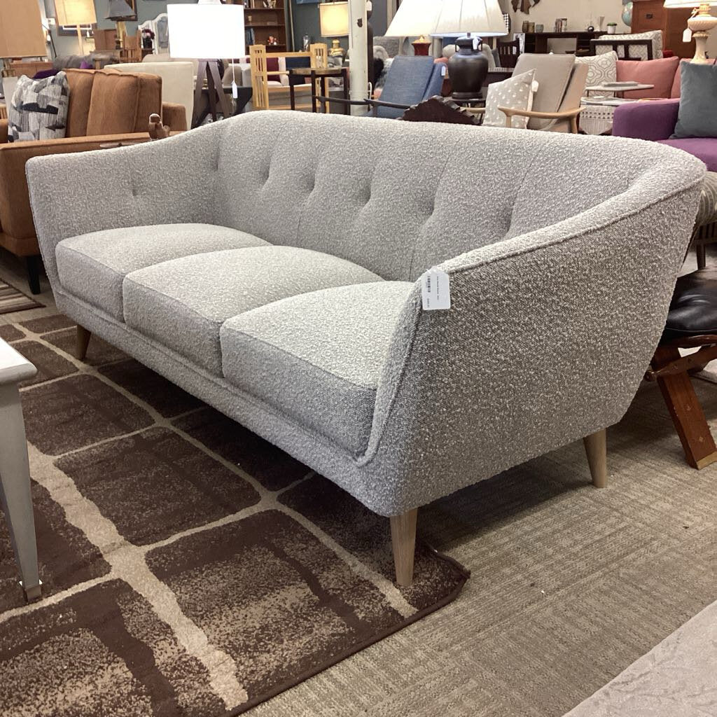 Gray sofa with a price tag in a furniture store setting