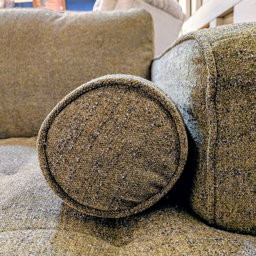 Textured brown fabric on a sofa with visible wear and tear.
