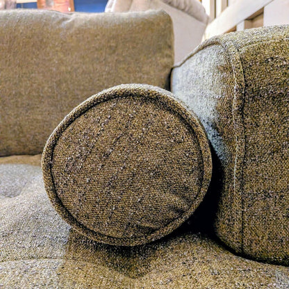 Textured brown fabric on a sofa with visible wear and tear.