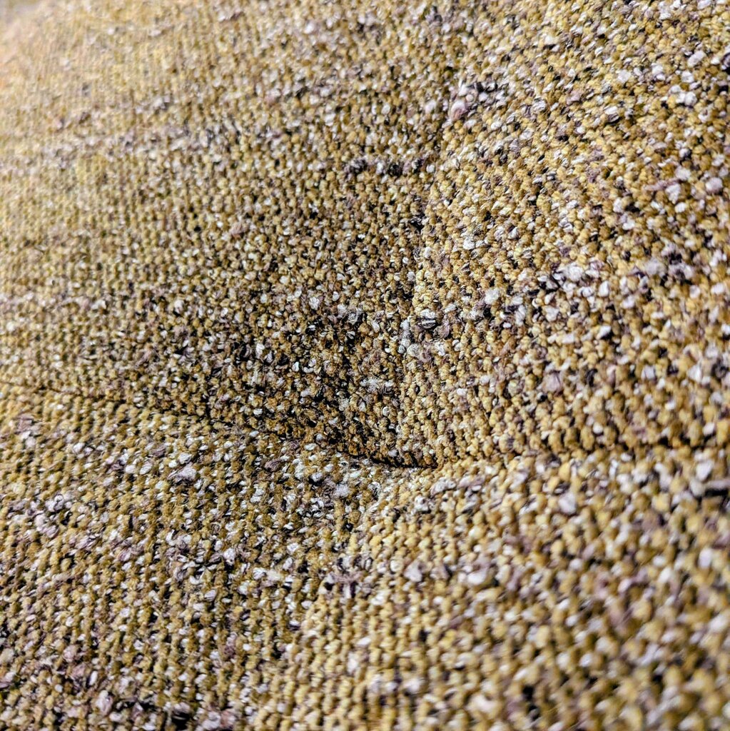 Close-up of textured beige fabric with small stones embedded