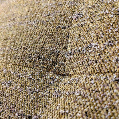 Close-up of textured beige fabric with small stones embedded