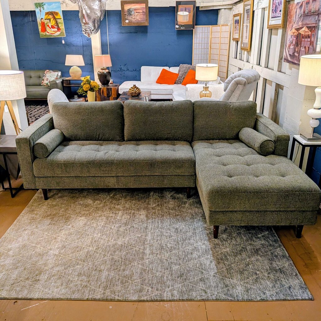 Gray sectional sofa in a living room setting with decor elements.