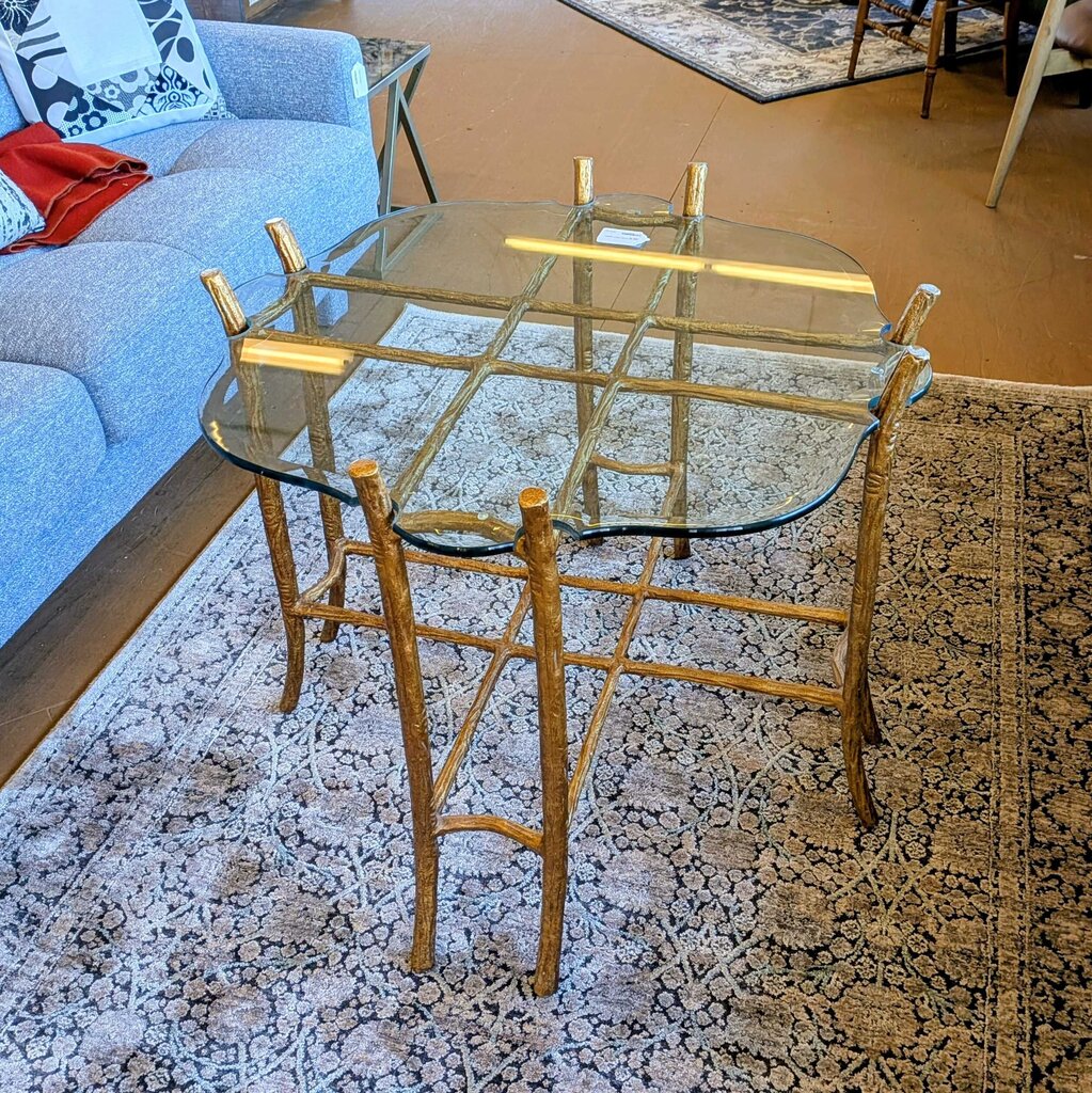 Glass dining table with gold metal frame on a patterned rug