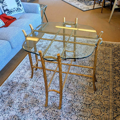 Glass dining table with gold metal frame on a patterned rug